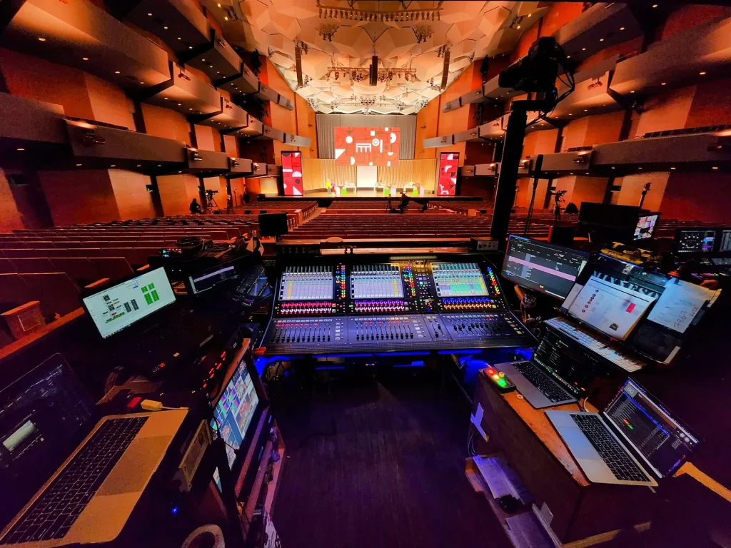 Front of house audio mixing console and control setup in a large conference venue during a live event production